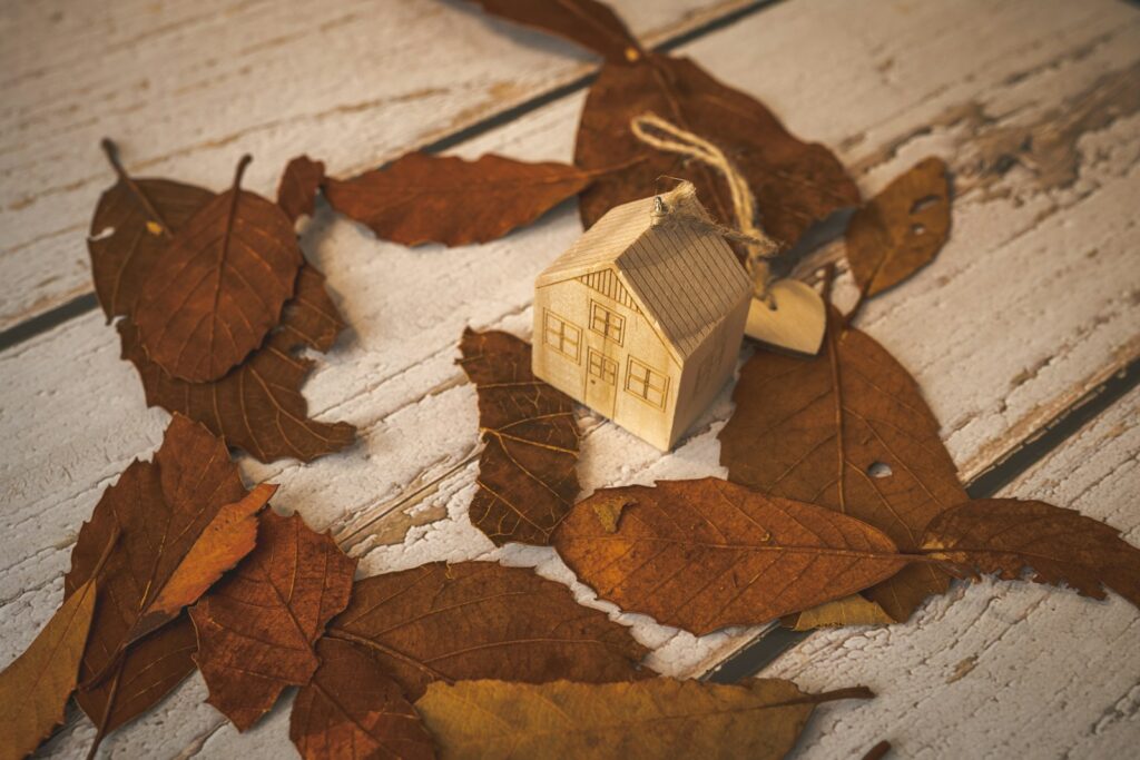 a small wooden house sitting on top of a pile of leaves