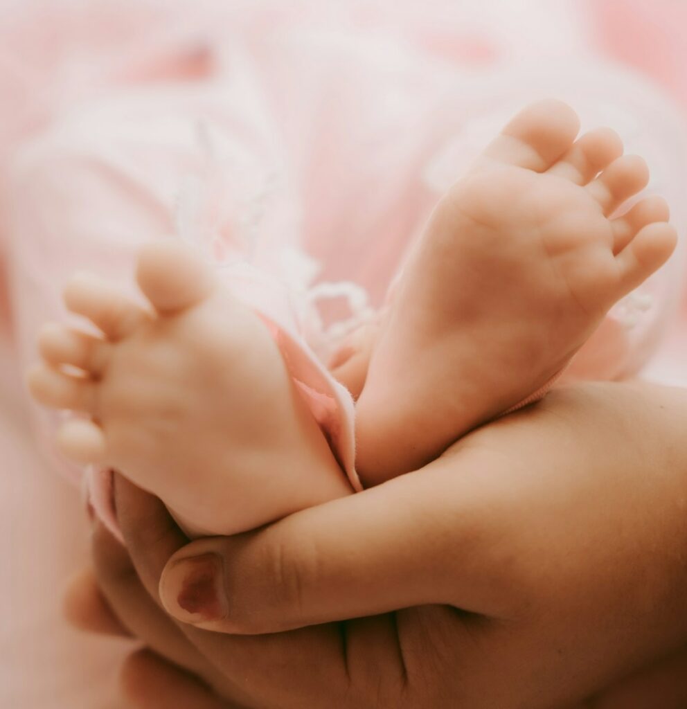 a close up of a person holding a baby's foot